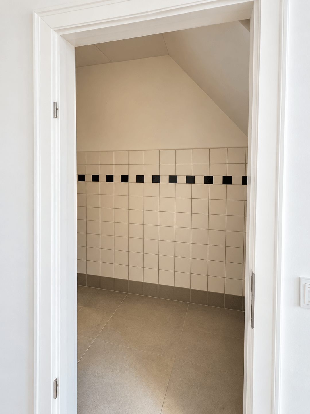 Raum mit markanter Fliesenbordüre